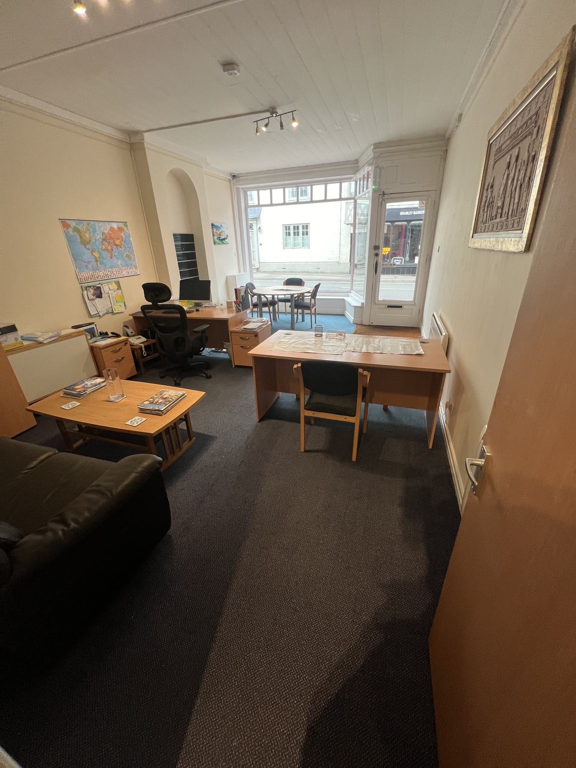 The interior as an office, with desks and a world map