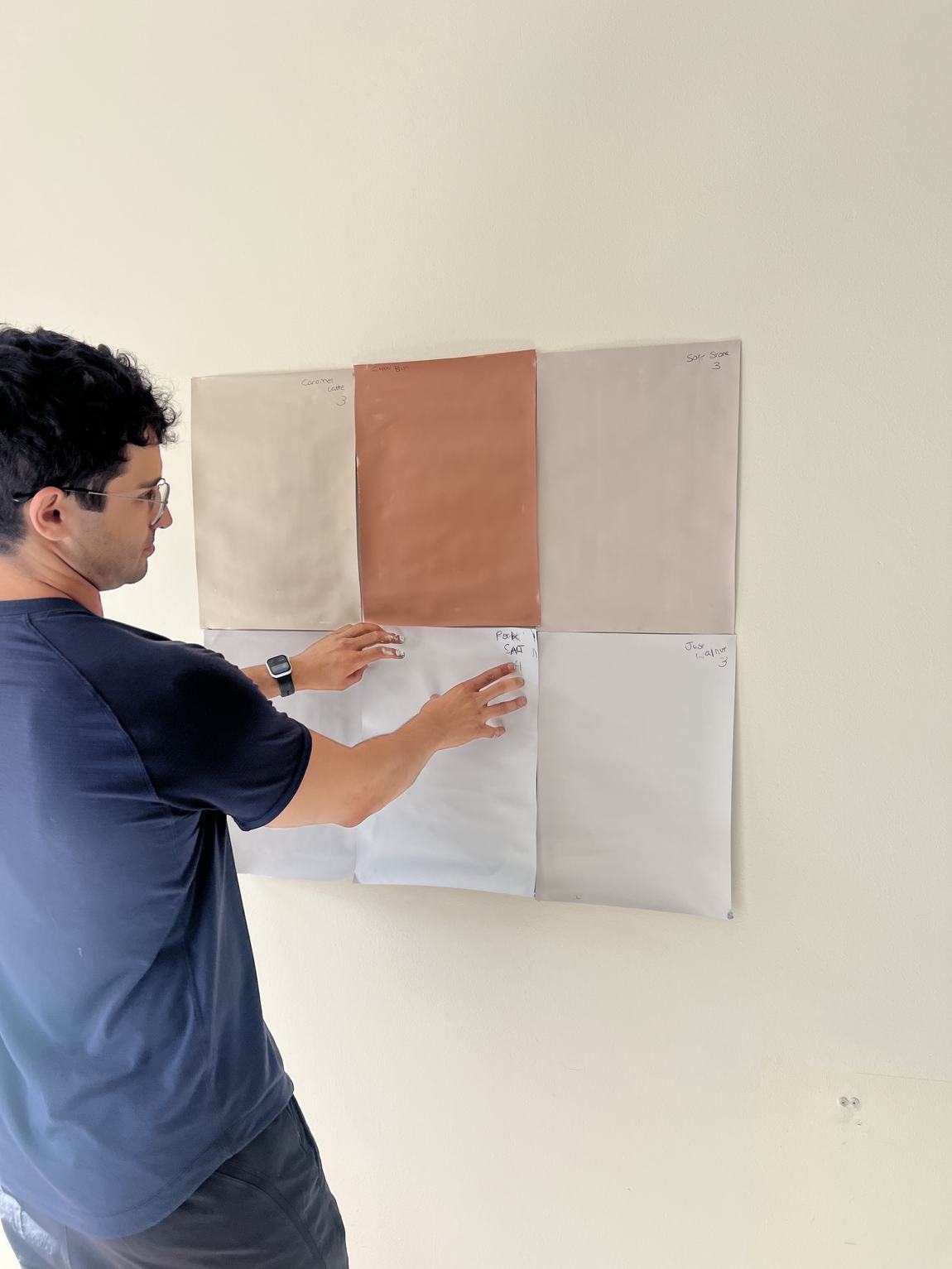 Taping swatches to the wall to compare them