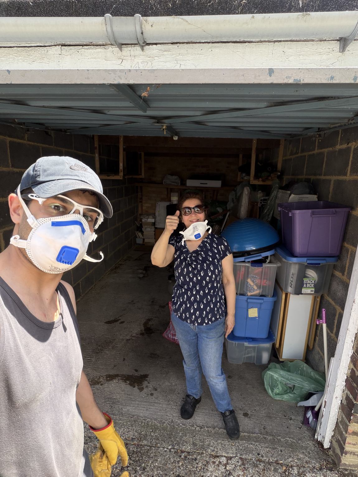 Ramin and his mother in dust masks clearing the garage