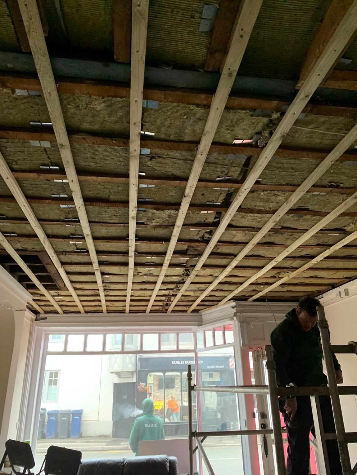 Carpenters levelling the ceiling with battens