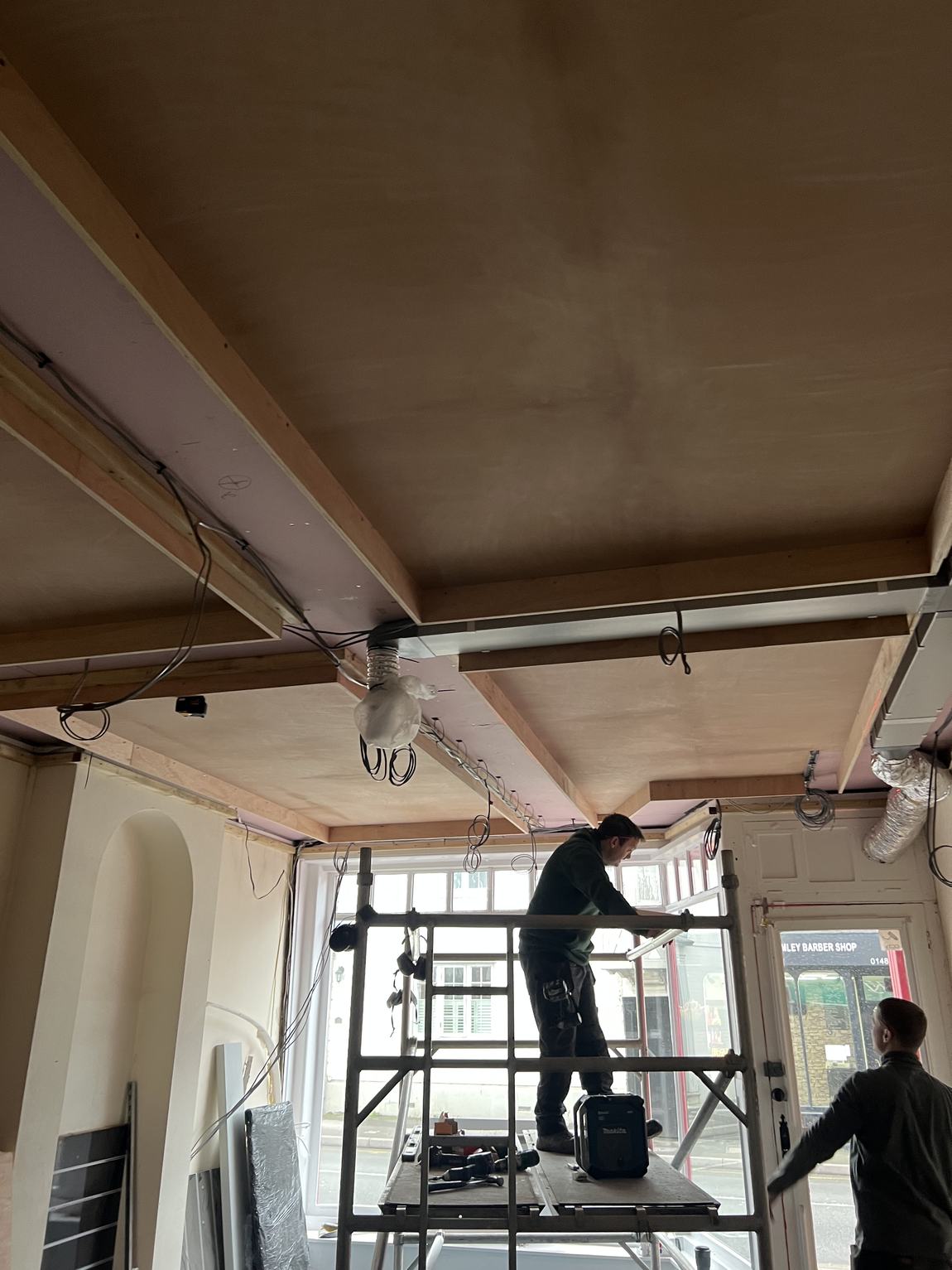 Carpenters finishing the ceiling from a scaffold tower